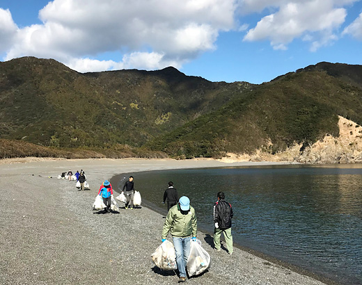 拾い集めたゴミを海岸まで運ぶ様子