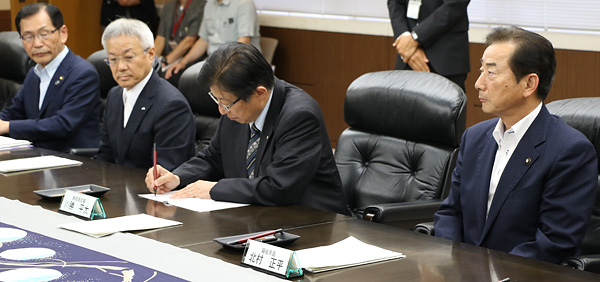 川勝静岡県知事が協定書に署名する様子